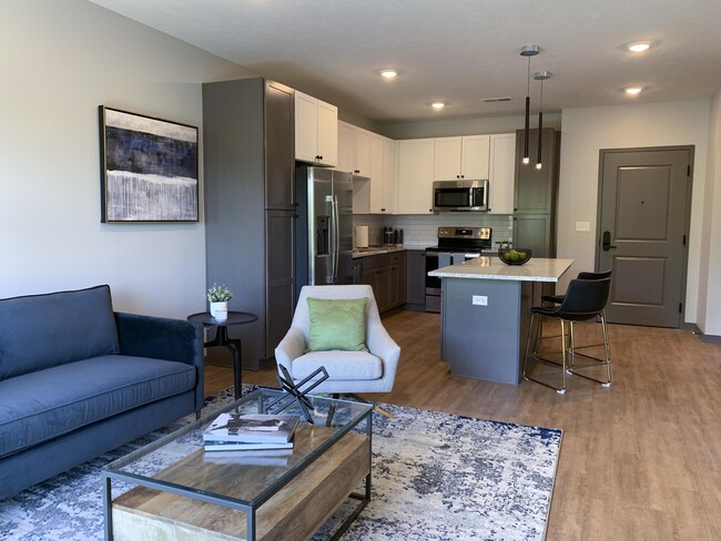 Open-concept living spaces combine modern kitchens with cozy lounge areas, creating the perfect home for relaxation and connection. - Haven at Uptown Apartments