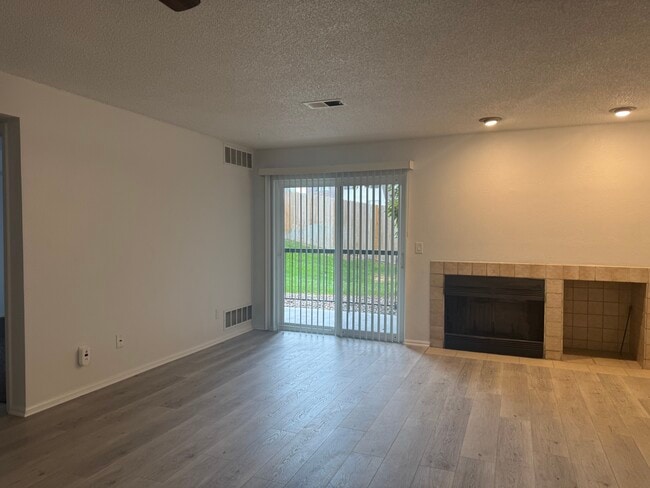 Sala de estar de concepto abierto con chimenea de leña y área de almacenamiento de leña. - 2575 S Syracuse Way Unidad J108