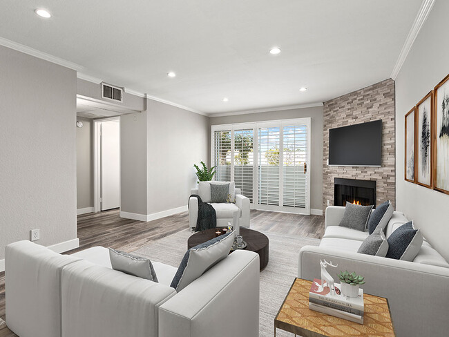 Hardwood floored living room with stone accented fireplace. - Magnolia Terrace Apartments