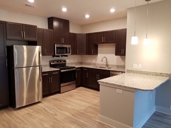 Beautiful kitchens with stainless steel appliances, granite countertops and wood-toned LVT