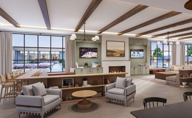 Stylish resident lounge with wood-beamed ceiling, TVs, fireplace, and large windows overlooking an outdoor courtyard - Oakwood Trails