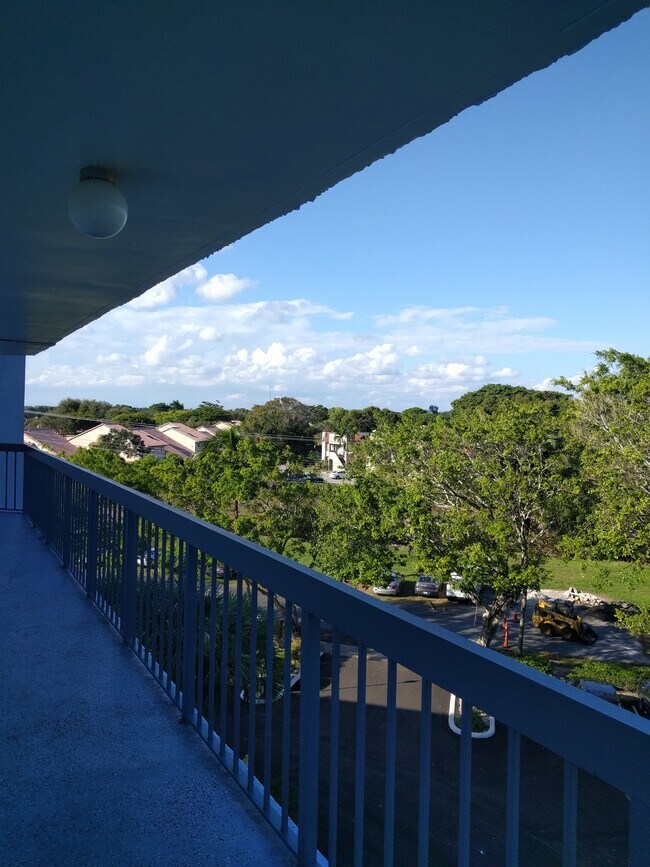 Front balcony with beautiful treelined views. - 198 NW 67th St Unit 504