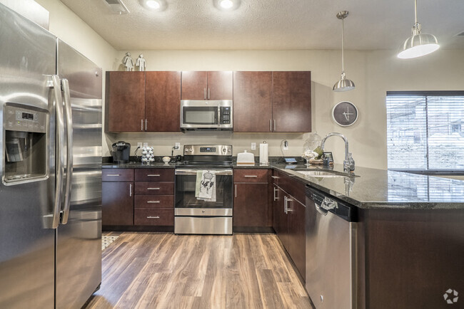 Our traditional design scheme features rich, dark cabinetry with darker granite countertops. - The Villas at Falling Waters Rental