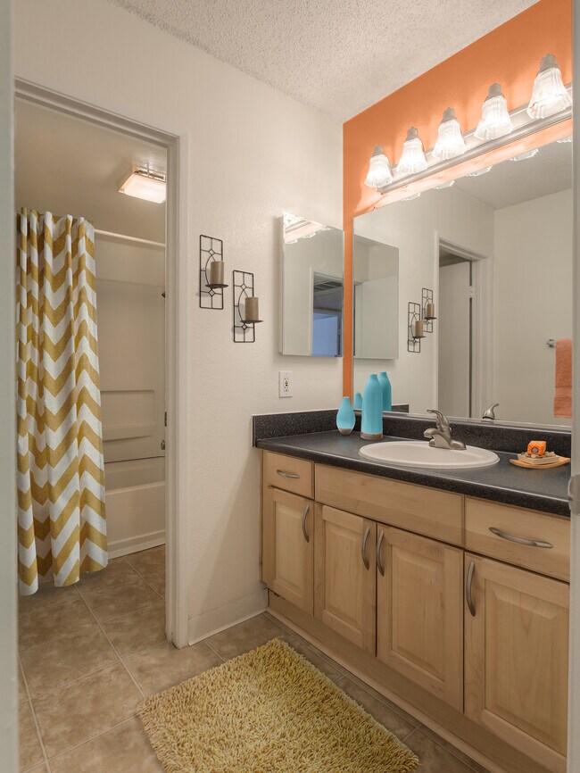 Baths with black laminate countertops and maple cabinetry
