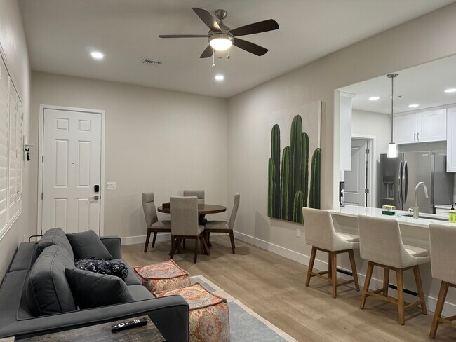 Living area with couch, four-seating dining table, beautiful vinyl floors, ceiling fan - 2040 E River Rd Unidad 202