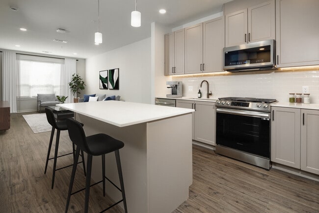 Upgrade Scheme kitchen with stainless steel appliances, white quartz countertops, grey cabinetry, and hard surface flooring