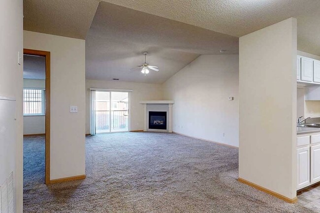 Las espaciosas áreas de estar y comedor se combinan sin esfuerzo, creando un espacio cálido y acogedor para la vida diaria o el entretenimiento junto al fuego. - Northbrook Apartments