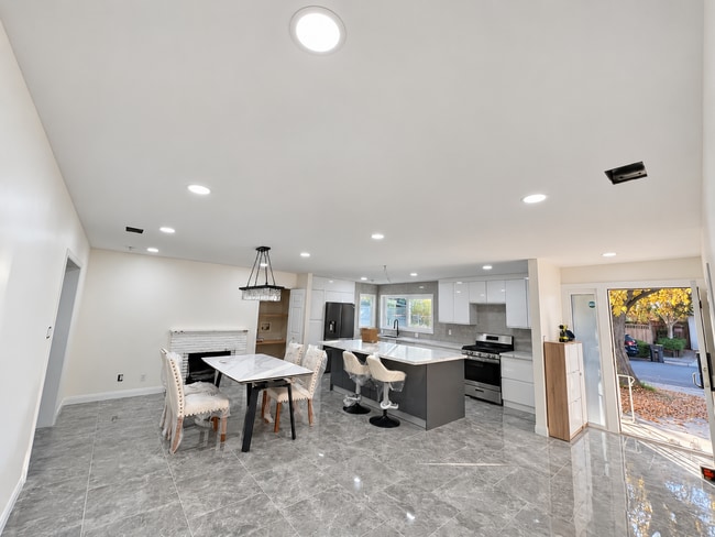 Cocina remodelada con una gran isla central, gabinetes modernos y electrodomésticos de acero inoxidable.
