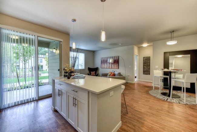Kitchen Island with Dining Area and View of Private Patio - Madison Bellevue Apartments