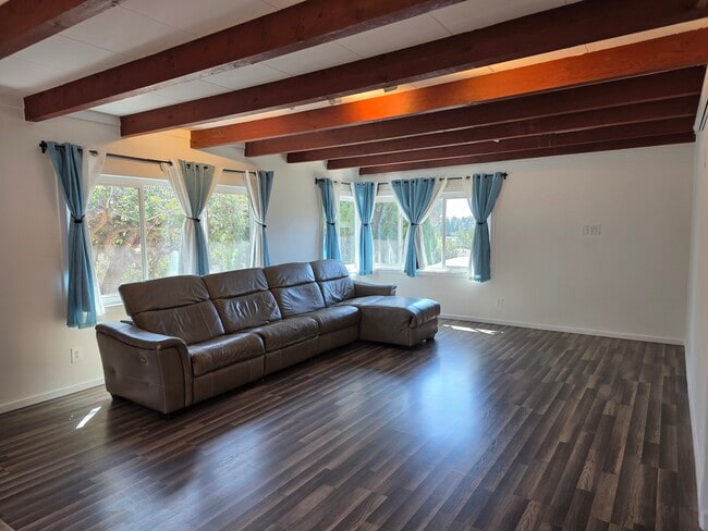 View of the living room. Plenty of natural light with trees for privacy. Couch optional.