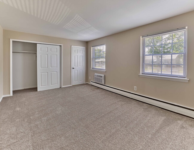 Bright and roomy bedroom with plush carpet and ample closet space at Maple Terrace Apartments in Maple Shade, NJ