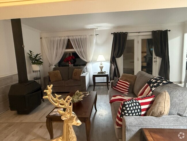 Living area with wood stove burning fireplace. - 1053 Danby Rd Unit 1 Rental