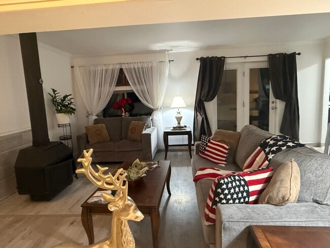 Living area with wood stove burning fireplace. - 1053 Danby Rd Unit 1 Rental