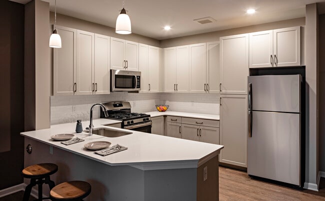 Modern kitchens with grey cabinetry, white quartz countertops, tile backsplash, stainless steel appliances, and hard surface flooring