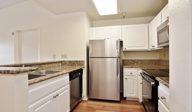 Kitchen with granite countertops, stainless steel appliances and a breakfast bar