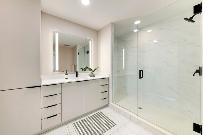 Tower Building - Renovated II bath with white quartz countertop, light grey cabinetry, and tile flooring
