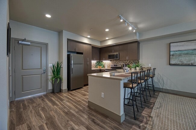 Warm kitchen entry with a chef island, open layout, and seating that supports easy conversation and meals. - Vespaio