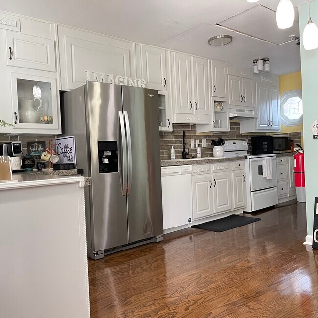 A cozy, modern kitchen featuring granite countertops, stainless steel refrigerator, perfect for cook - 2171 Weatherstone Cir SE Apartamentos Unidad Johns