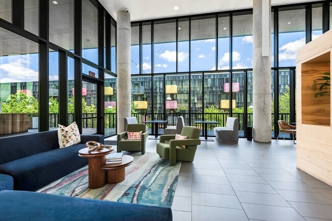 Salón interior con vista al patio, con sofás seccionales y sillas. - Lamar Union