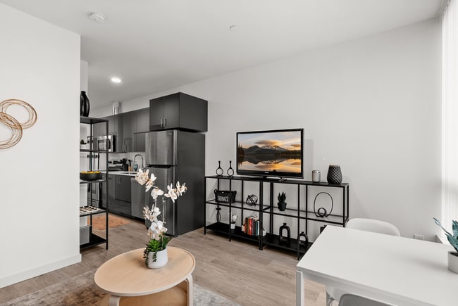 Sala de estar de concepto abierto con cocina moderna y acabados elegantes. - The Ruby