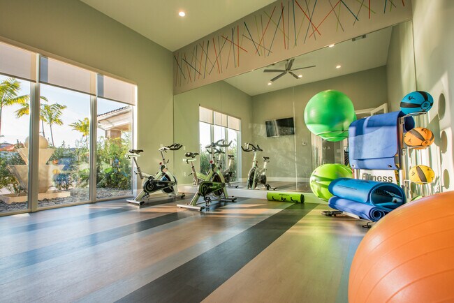 Estudio de fitness con bicicletas de spinning y zona de estiramientos.