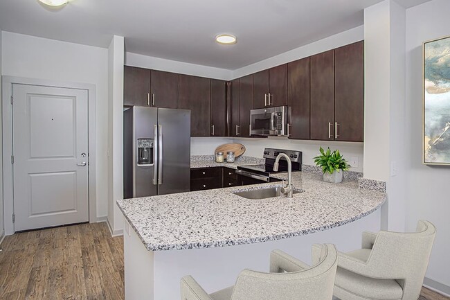 Beautifully renovated kitchens feature granite countertops and stainless steel appliances - Gramercy Square at Ayrsley Apartments