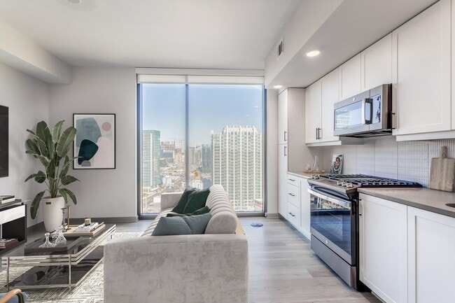 Studio Living Area and Kitchen with Floor to Ceiling Windows and Views of the City