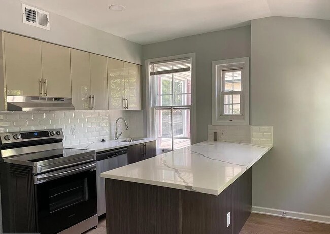 Modern kitchen featuring quartz countertops, stainless steel appliances, subway tile backsplash, and - 453 Lancaster Ave Unit 2