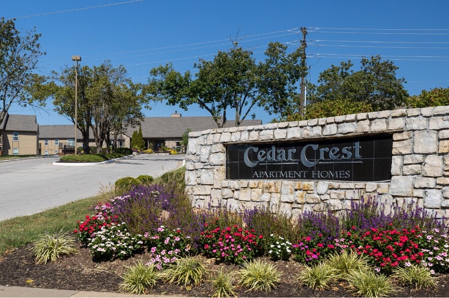 A welcoming entrance to Cedar Crest Apartments, featuring beautifully maintained signage and landscaping.