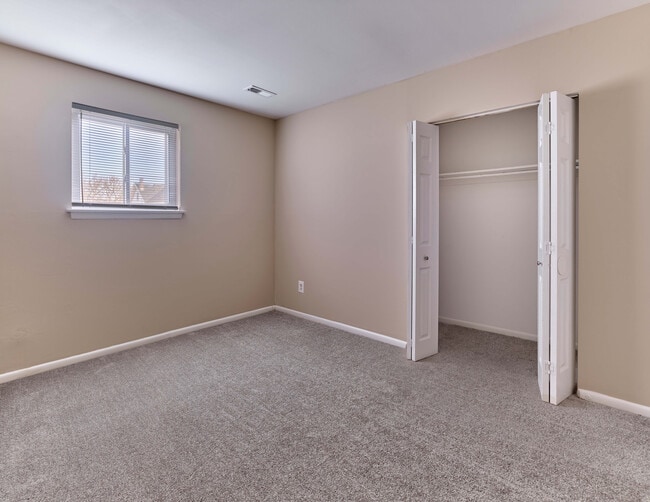 Cozy carpeted bedroom with generous closet space at Village Square.