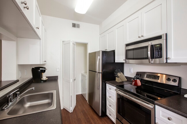 Classic Package I kitchen with stainless steel appliances, white cabinetry, laminate countertops, and hard surface flooring