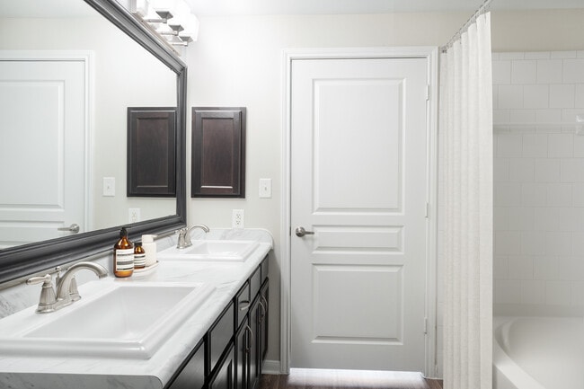 Bath with espresso cabinetry, quartz or granite countertop, and hard surface vinyl plank flooring