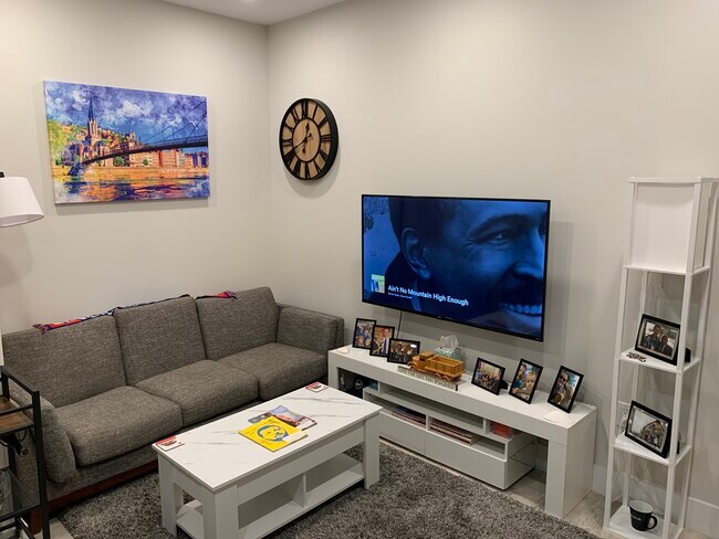 Furnished living room with coffee table and mounted 55" Smart TV. - 2556 University Pl NW Condo Unit 2