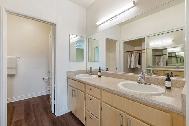 Renovated Package I bath with laminate countertops, oak cabinetry, and updated hard surface flooring