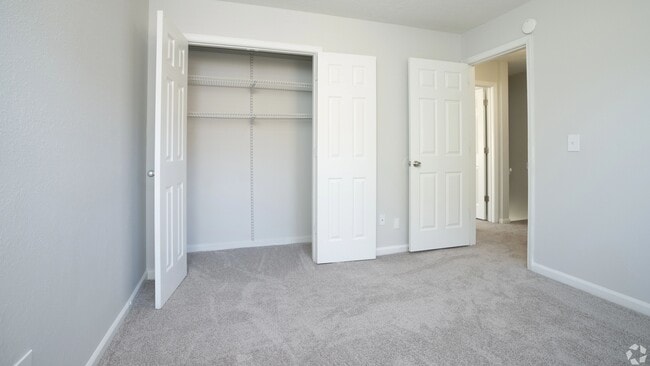 Spacious guest bedroom featuring a large closet with built-in shelving and plush carpeting, perfect for a cozy and inviting guest space. - Legacy at West Cobb