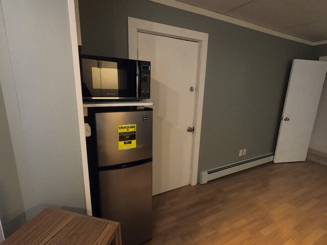 Small kitchenette of a refrigerator and combination microwave/oven. - 303 Hanover St Unit 3