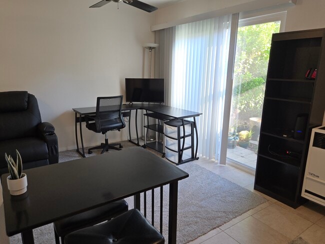 View from kitchen into living room area. Workstation, massaging reclyner, wall shelving unit