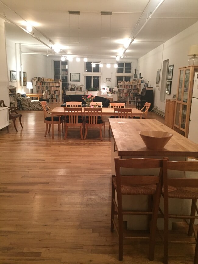 Main space with 8' maple dining table and island counter - 471 Broadway Unit #2
