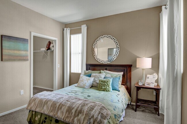 A bedroom with a large closet and windows overlooking the property - Pala Mesa