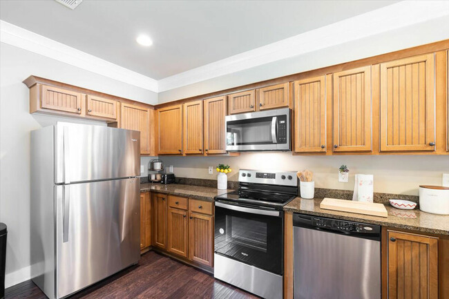 Enjoy modern, fully-equipped kitchens with granite counters and stainless steel appliances, perfect for student living. - The Cottages of Hattiesburg Rental