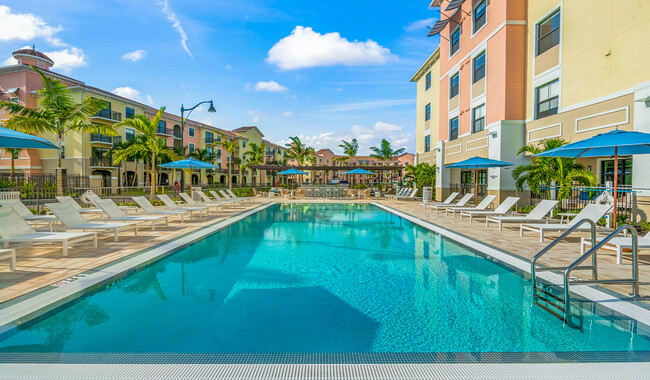 Unwind and relax at your spacious community pool. - The Reserve at Coconut Point Apartments