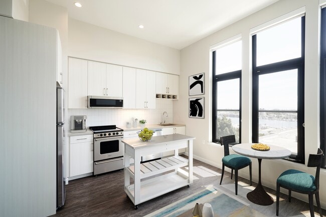 Stunning apartments with wood flooring, moveable island with storage, and stainless steel appliances. - Modera Jack London Square Apartments