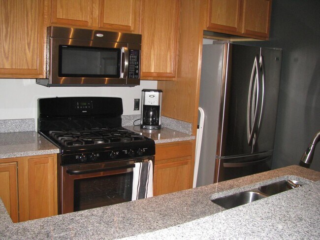 kitchen with granite counters, gas cooktop, ss appliances and good cupboard space - 360 W Washington Ave Unit 305