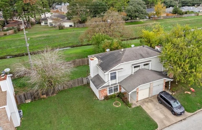 Aerial perspective showing the multi-story structure nestled on a spacious green property.