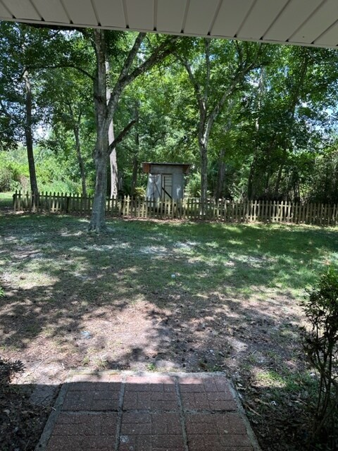 Rear yard divided by a picket fence. Bird cage - 212 Scotchpine Dr