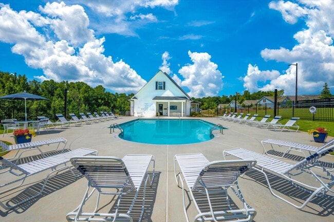 Resort-style pool with ample seating, lounge chairs and umbrellas.