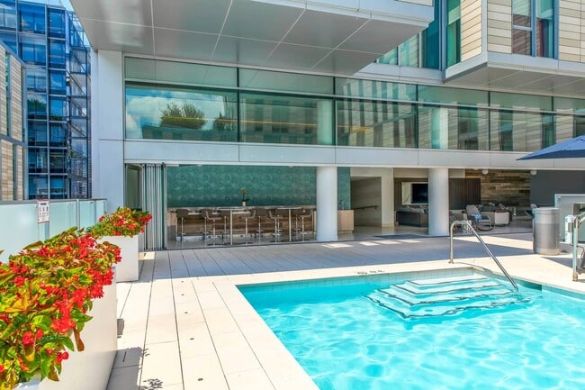 Comodidades de apartamentos de primer nivel que incluyen una elegante terraza con piscina, asientos en el bar a la sombra y un moderno espacio de salón interior y exterior perfecto para relajarse o entretenerse.