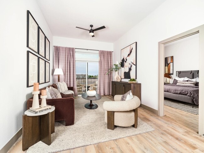 Bright living spaces feature wood-style flooring, elevated ceilings, and oversized windows that bring in abundant natural light.