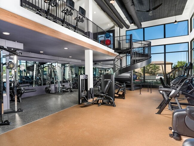 A spacious two-level fitness center at Modera Higley Commons, featuring expansive windows, advanced equipment, and room to train at your own pace.