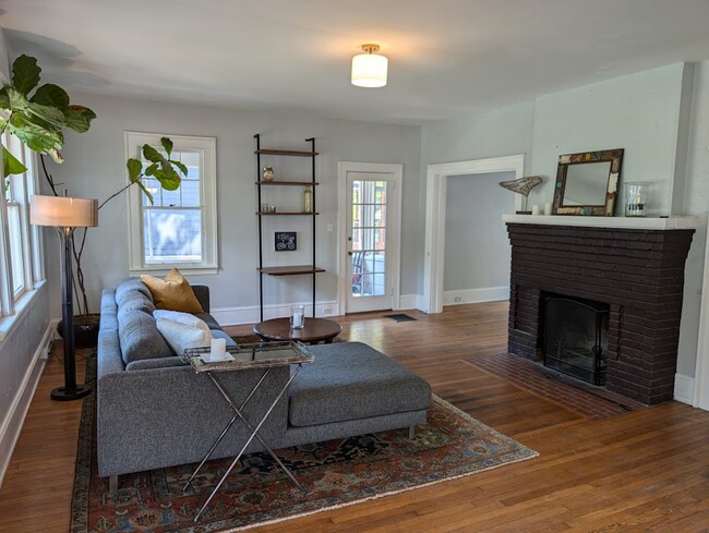 Cozy living room with wood-burning fireplace, Room & Board sectional, and a place to write. - 102 Murdock Ave House